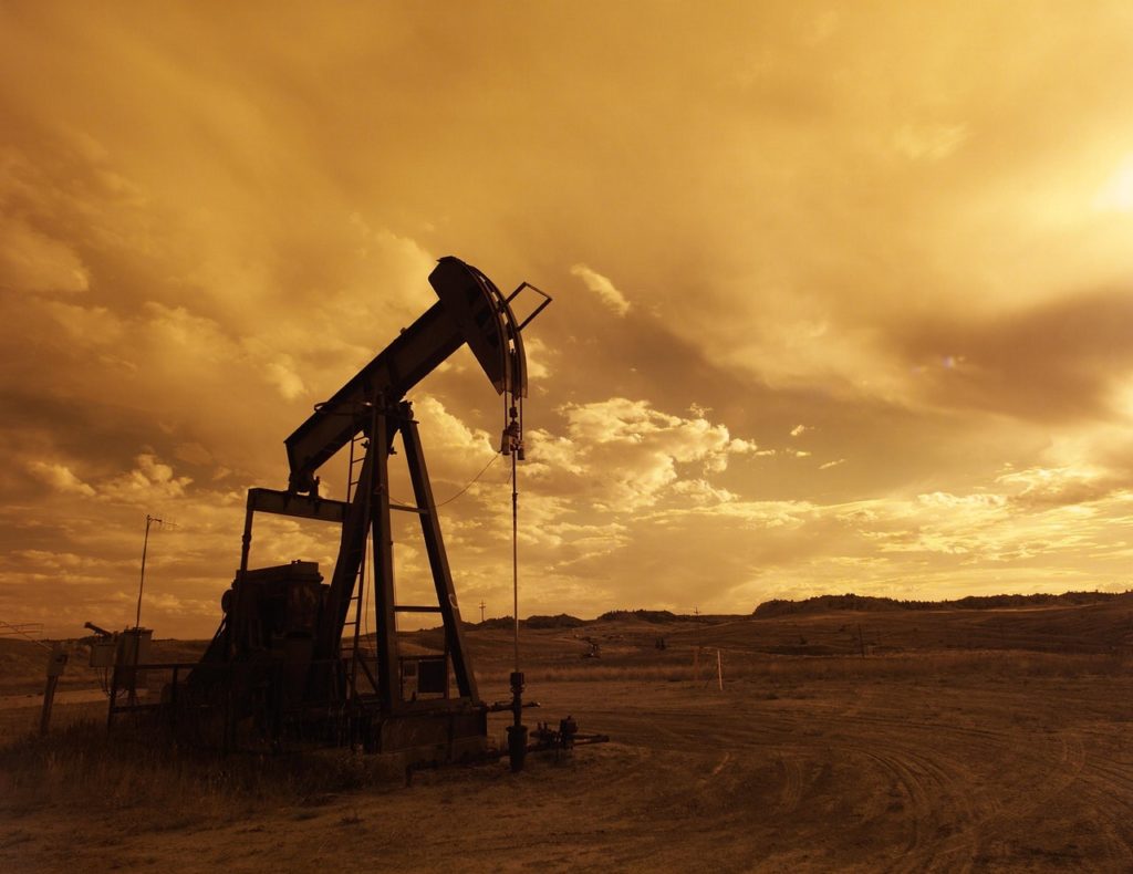 Oil rig in the desert at sunset
