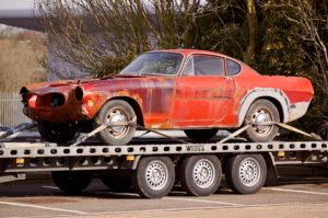 Rusted red car on trailer