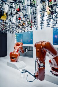 Two red robotic arms in a white room