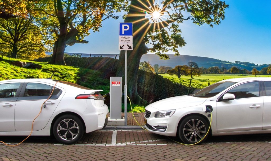Two white electric cars charging