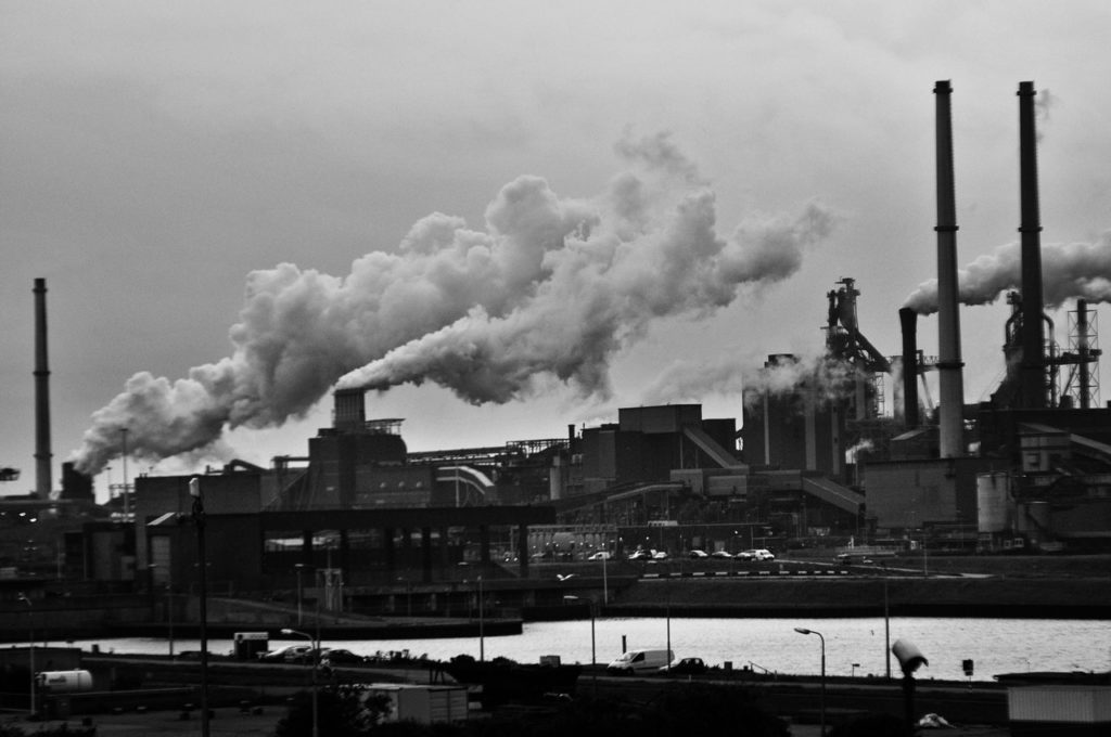 Skyline of a power plant producing smoke in black and white