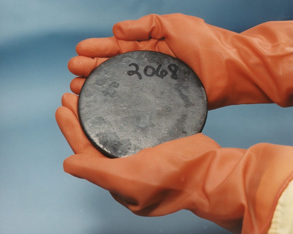 Radioactive uranium held in orange gloves