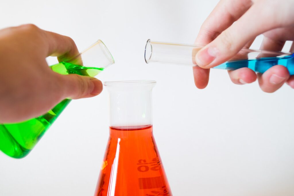 Test tubes of liquid being mixed into a flask