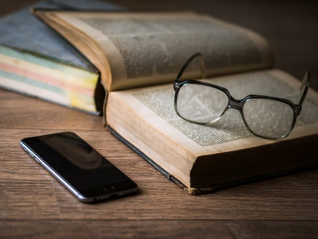 Glasses, book and phone on table