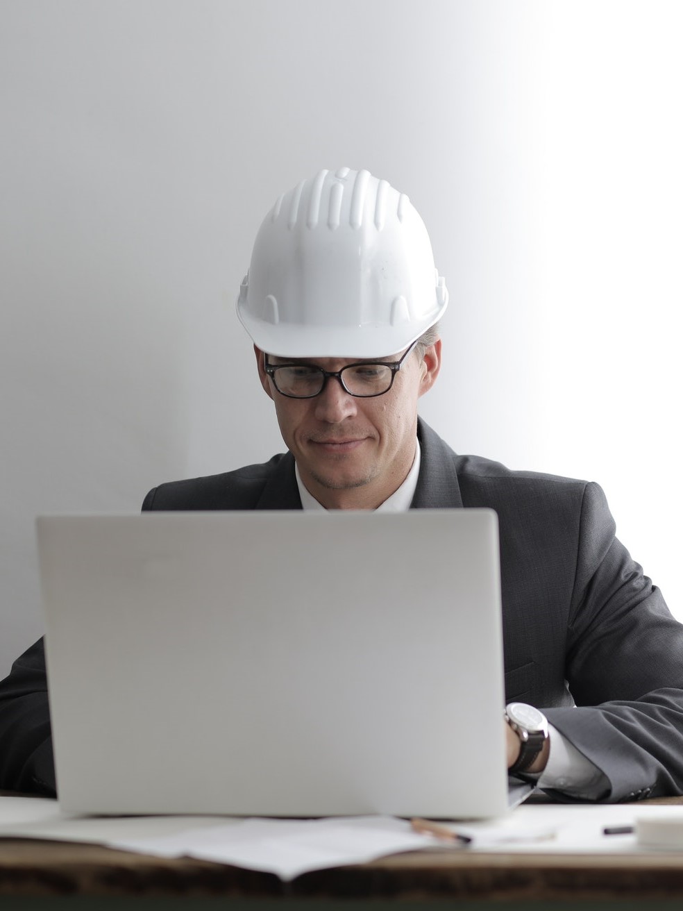Engineer sitting at desk with hard hat on