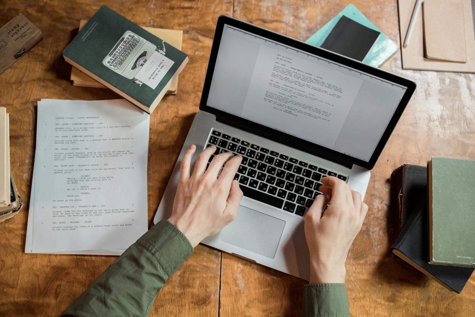 Man at desk writing on laptop